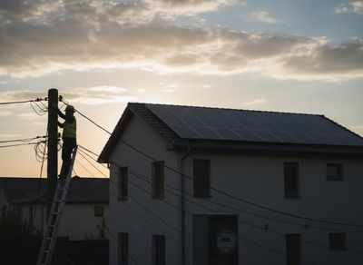 Utility Worker Near Solar-Powered Home